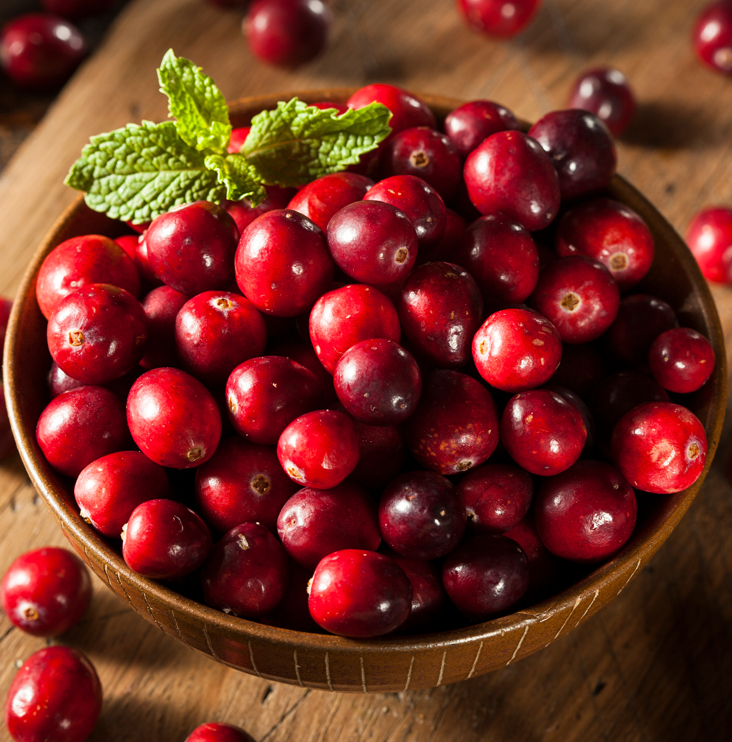 A wooden bowl filled with cranberries