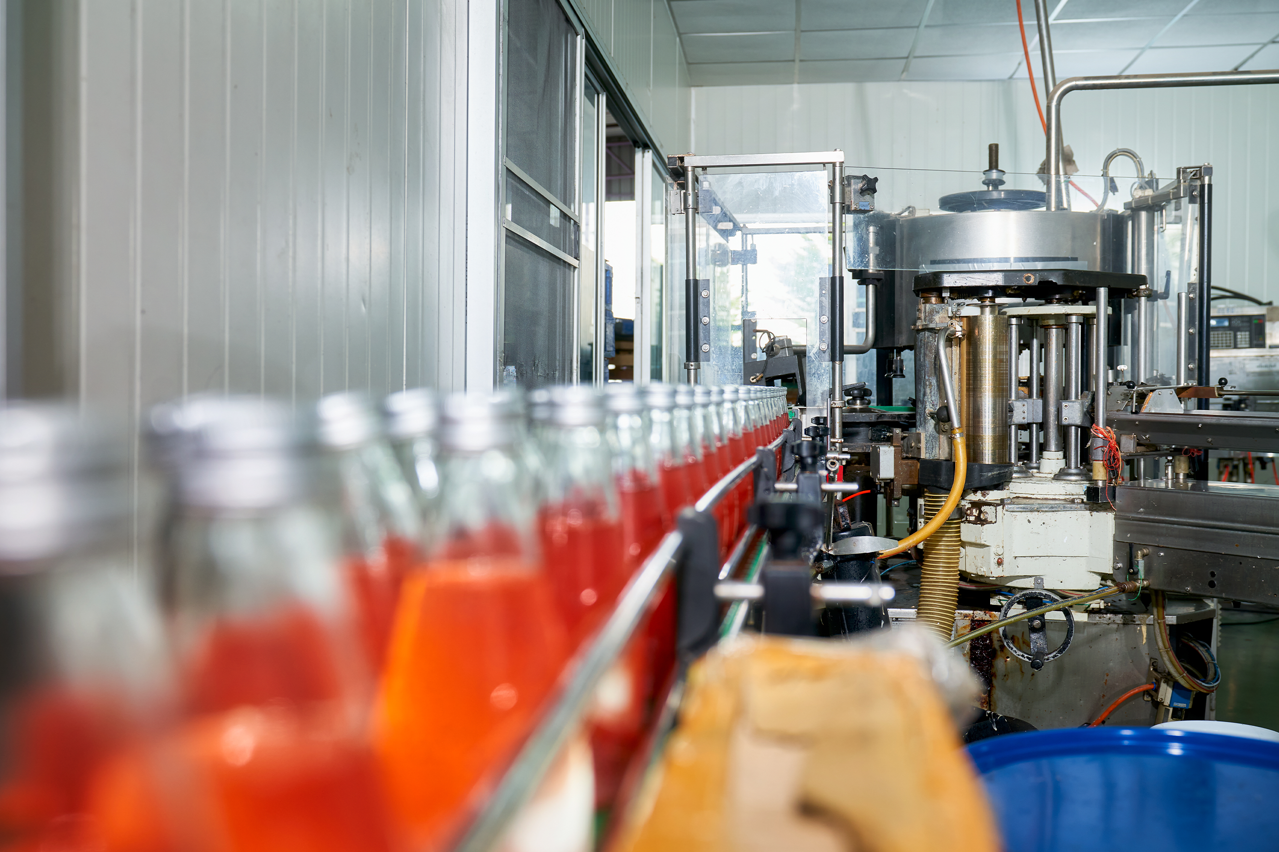 A juice processing line with several bottles of juice moving down the production line.